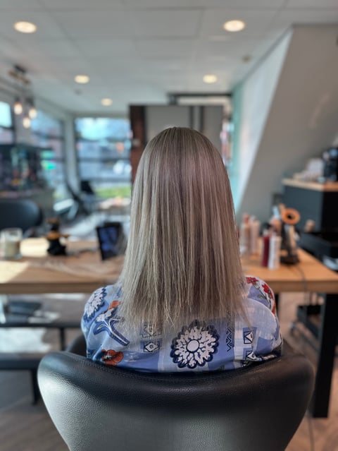 Vrouw met lang grijs haar in de salon, zijaanzicht