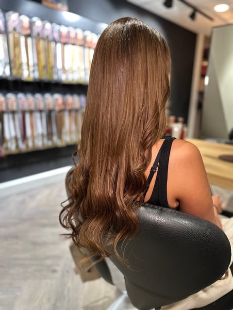 Vrouw met lang golvend bruin haar in bibliotheek