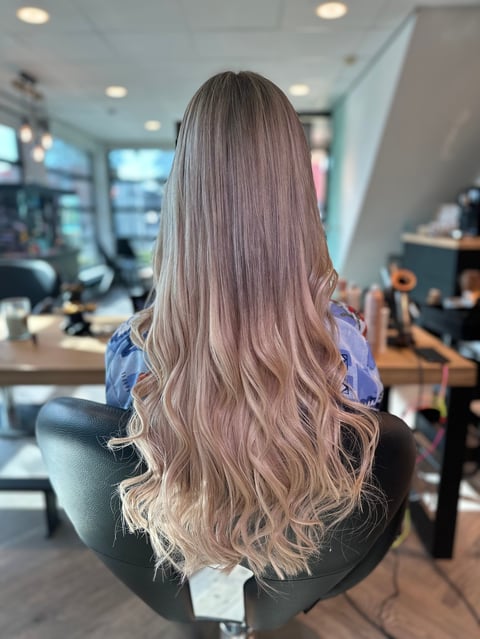 Vrouw met gelaagd asbruin haar met blonde highlights