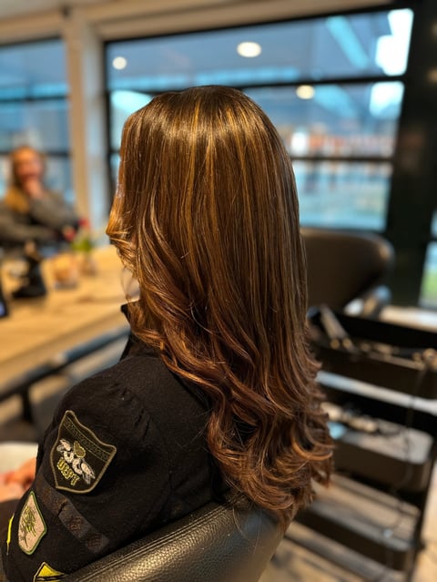 Vrouw met lang bruin haar in binnenruimte met ramen