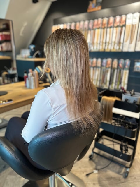 Vrouw met lang grijs haar in salonstoel, zijaanzicht